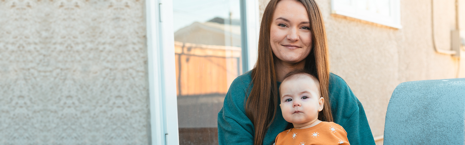 A mother holds her baby on her lap.