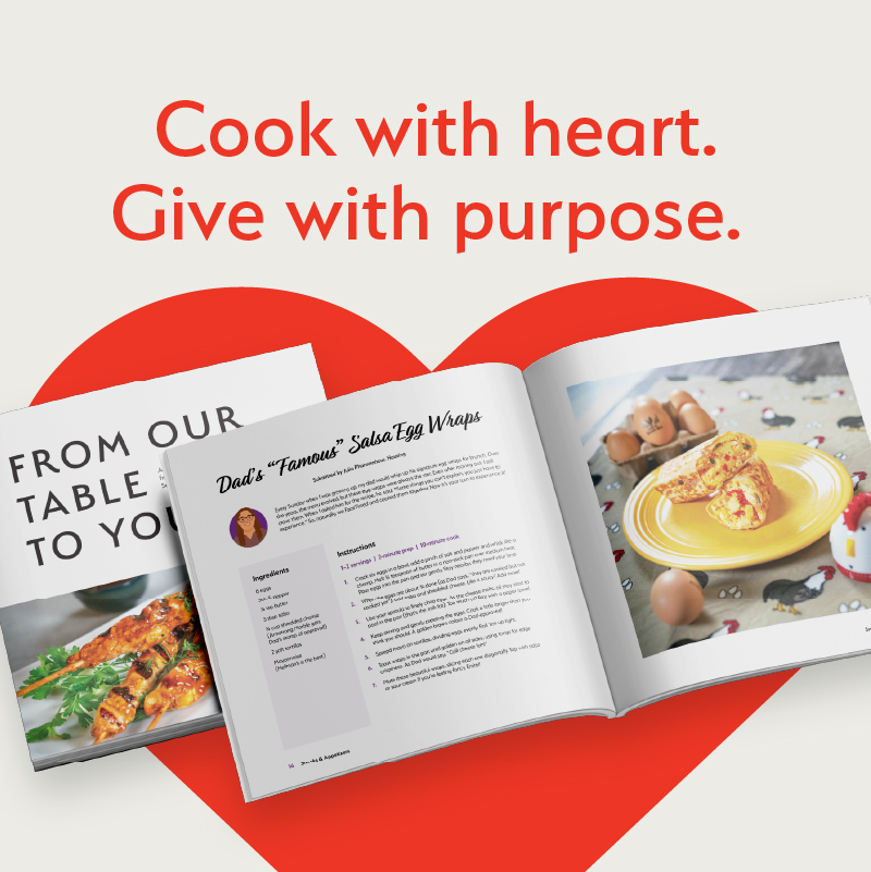 A cook book on top of a red heart.