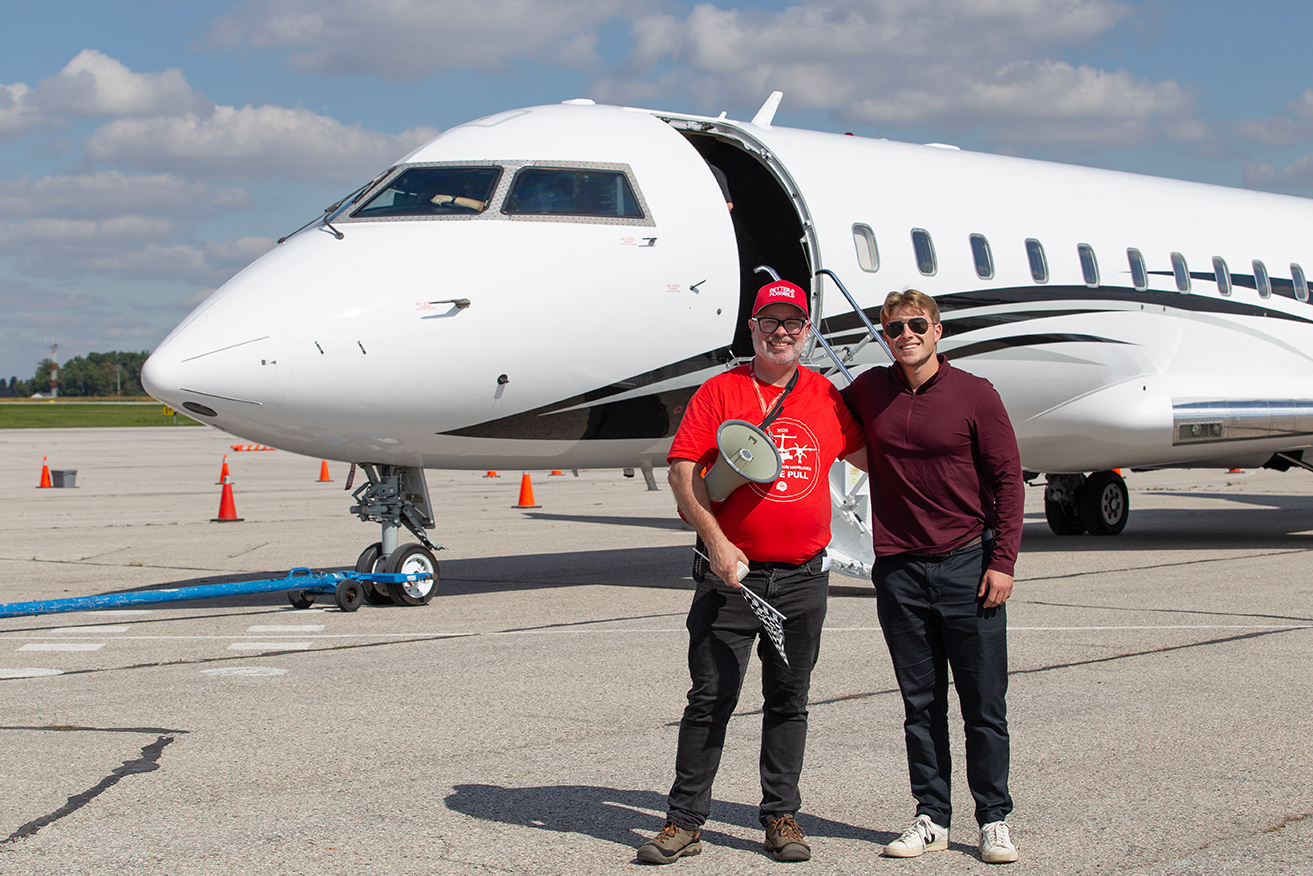 A member of the United Way staff stand with one of the pilots.